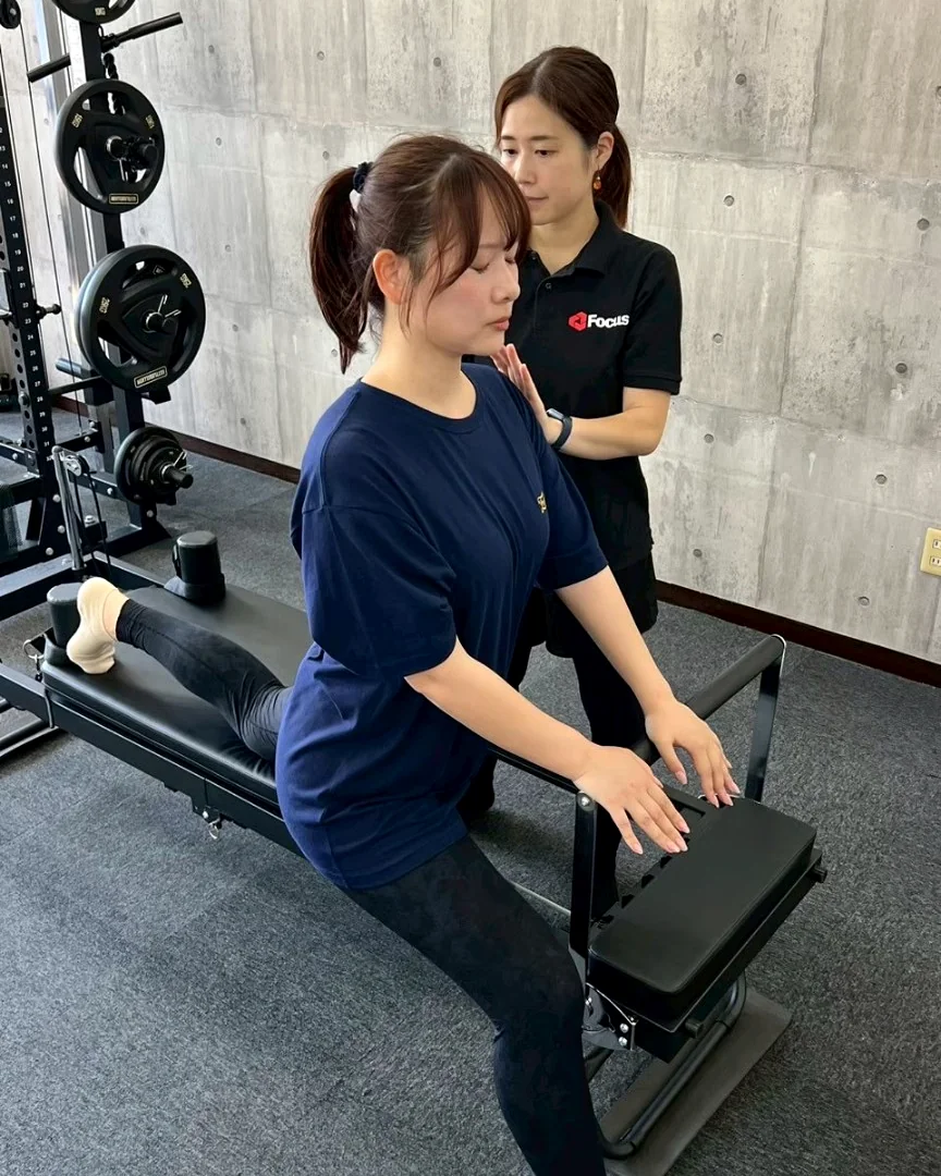 女性トレーナーが身体の使い方を確認する様子